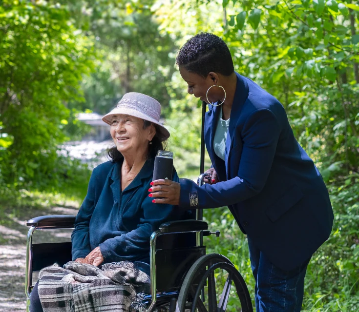 Regina with elderly woman in park Regina with elderly woman in park